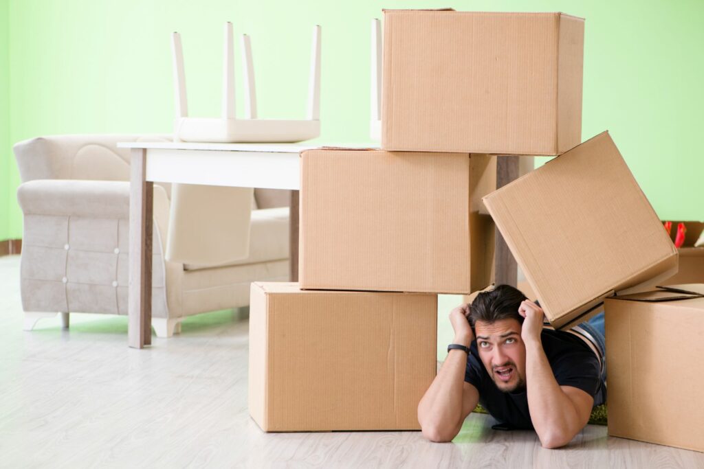 Man under a pile of boxes stacked around his head